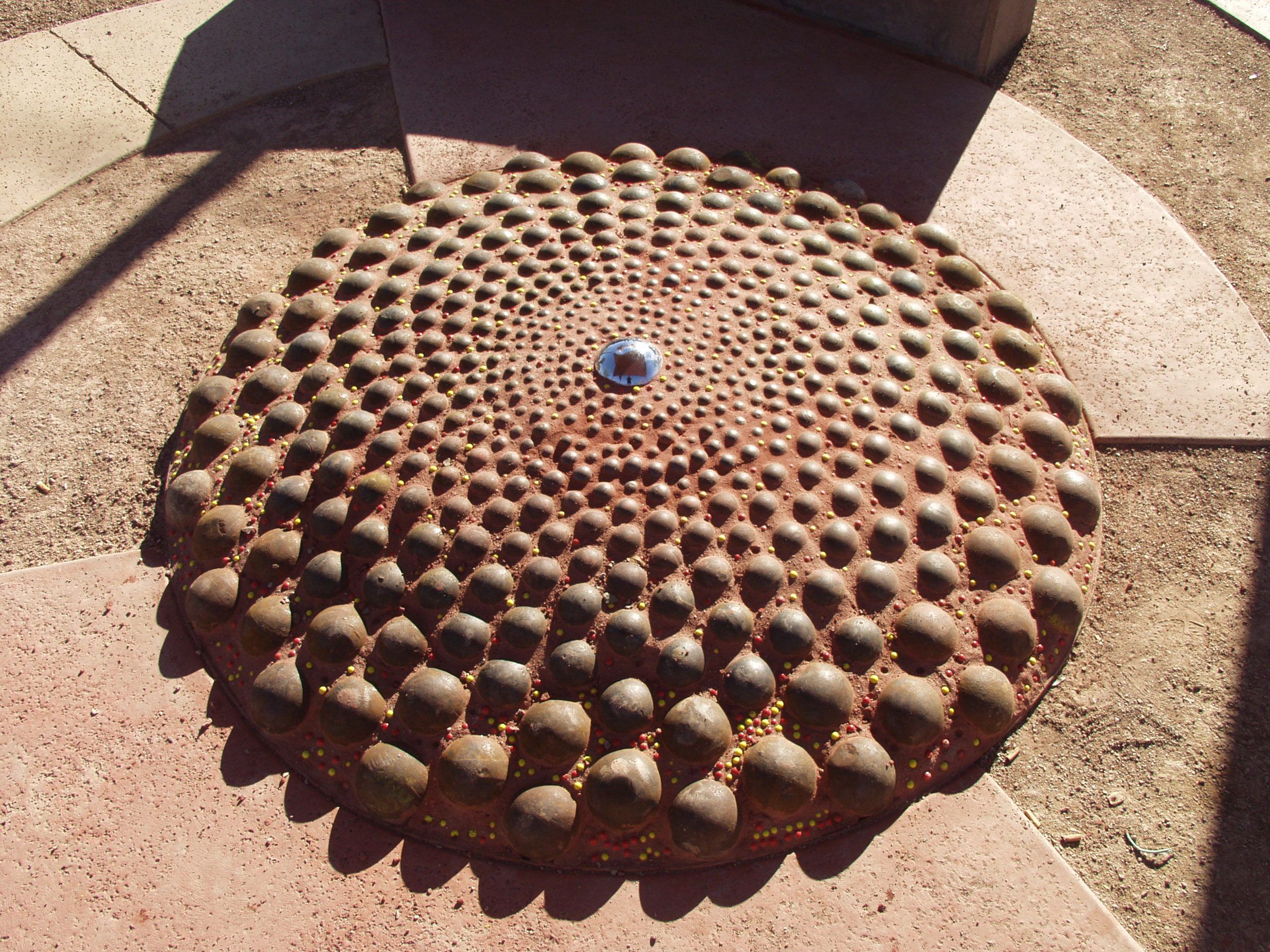 A sculpted dome of rounded stones set in red concrete